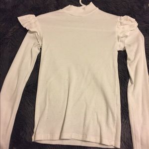 White turtleneck top with ruffled shoulders.